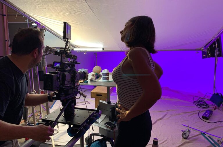 Camera crew filming an interview under coloured light