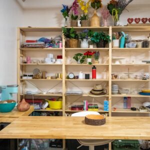 Floor to ceiling prop shelving and a wooden styling table