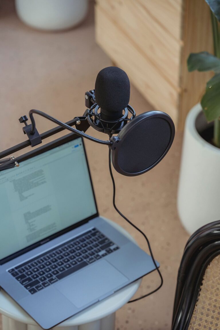 Laptop and microphone on a desk for customer outreach